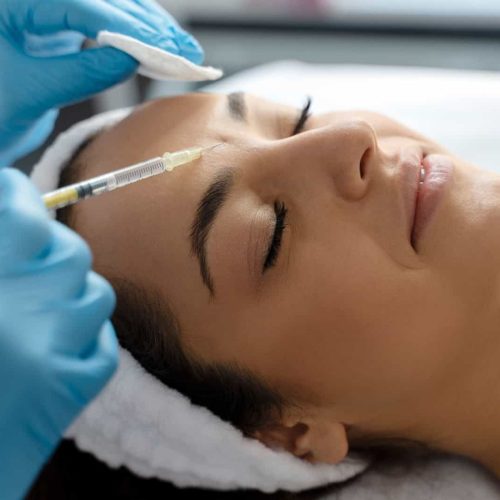 Cosmetologist does prp therapy on the face of a beautiful woman in a beauty salon